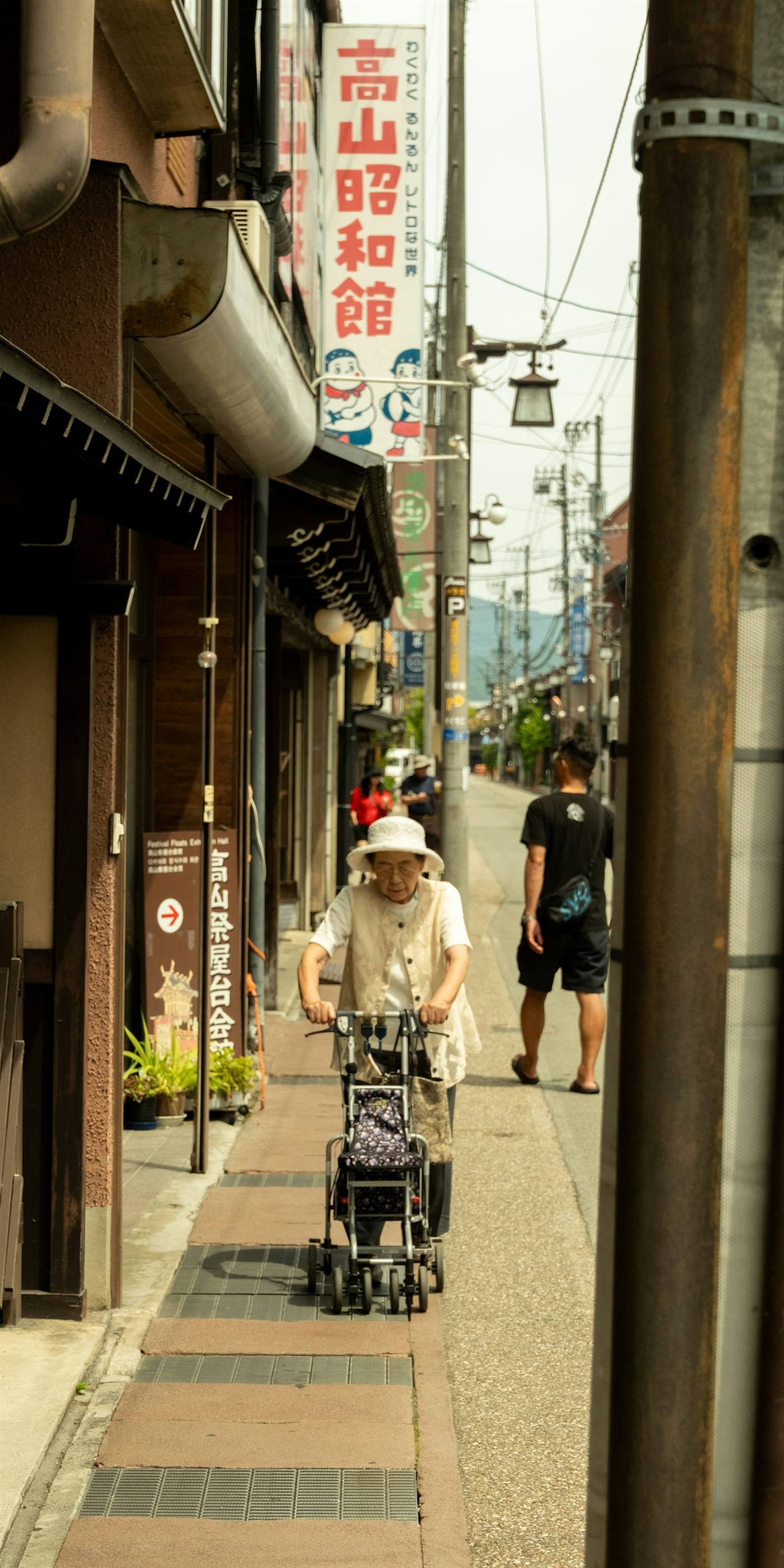 地域の商店街を自転車で走る高齢の男性